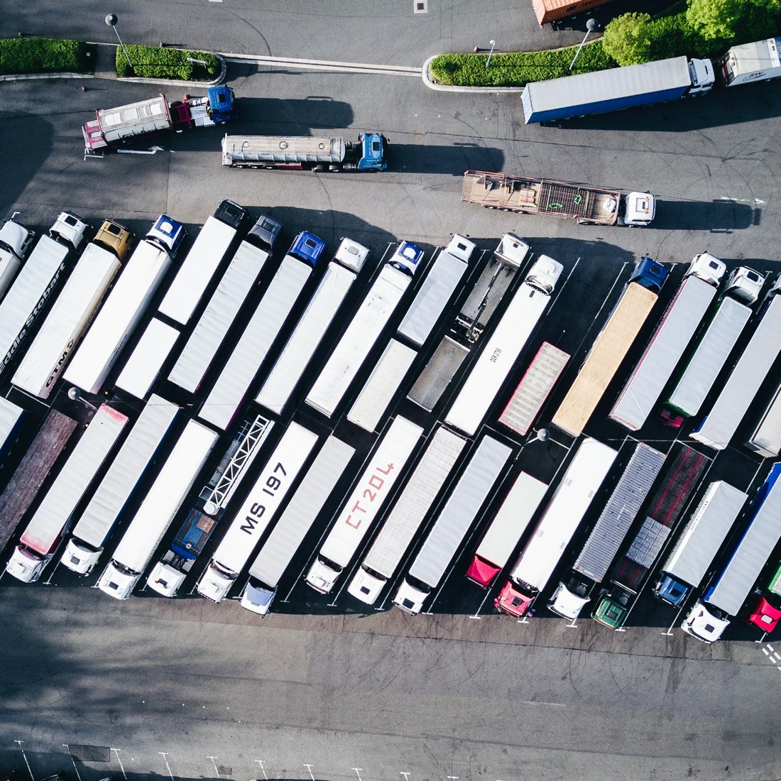 Freight trucks lined up in an ordered yard, seen from above