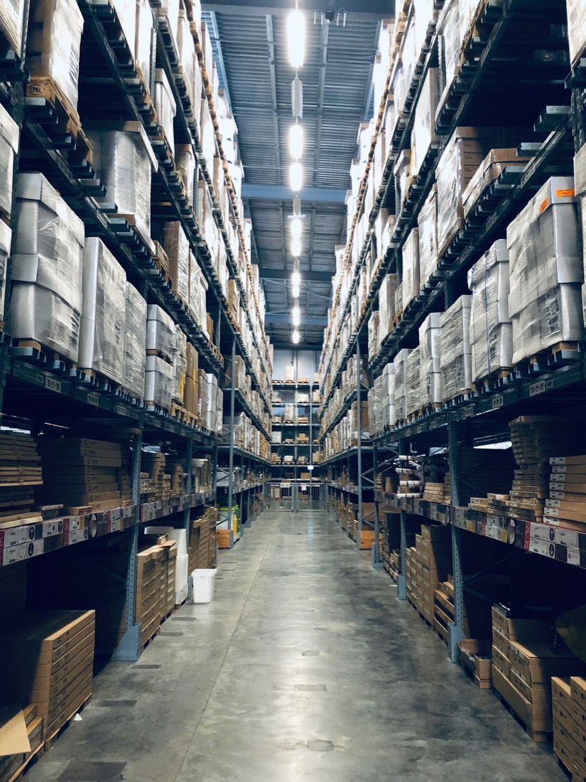 A tall warehouse aisle stocked to the ceiling